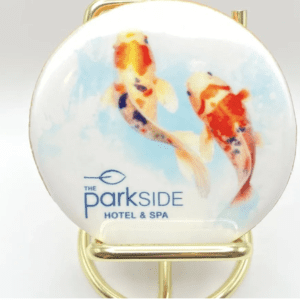 A round mirror with two fish on it.